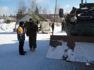 Cpl Gélinas explains to a member of the public what an Engineer LAV can do.
