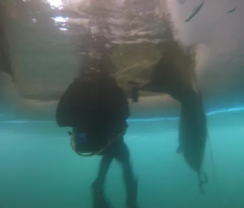 Member of 2 CER Dive team bringing down a body bag through ice // Un membre de l’équipe de plongée du 2 RGC emportant un sac mortuaire à travers la glace