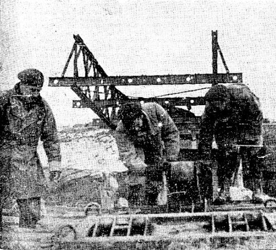 Sappers Andrew Ladouceur, Aylmer East, Que., and Thomas McGinnis, Elmvale, Ont. adjust rollers for a Bailey bridge across the Lamone River on one of the roads supplying Canadian units on the Senio River.