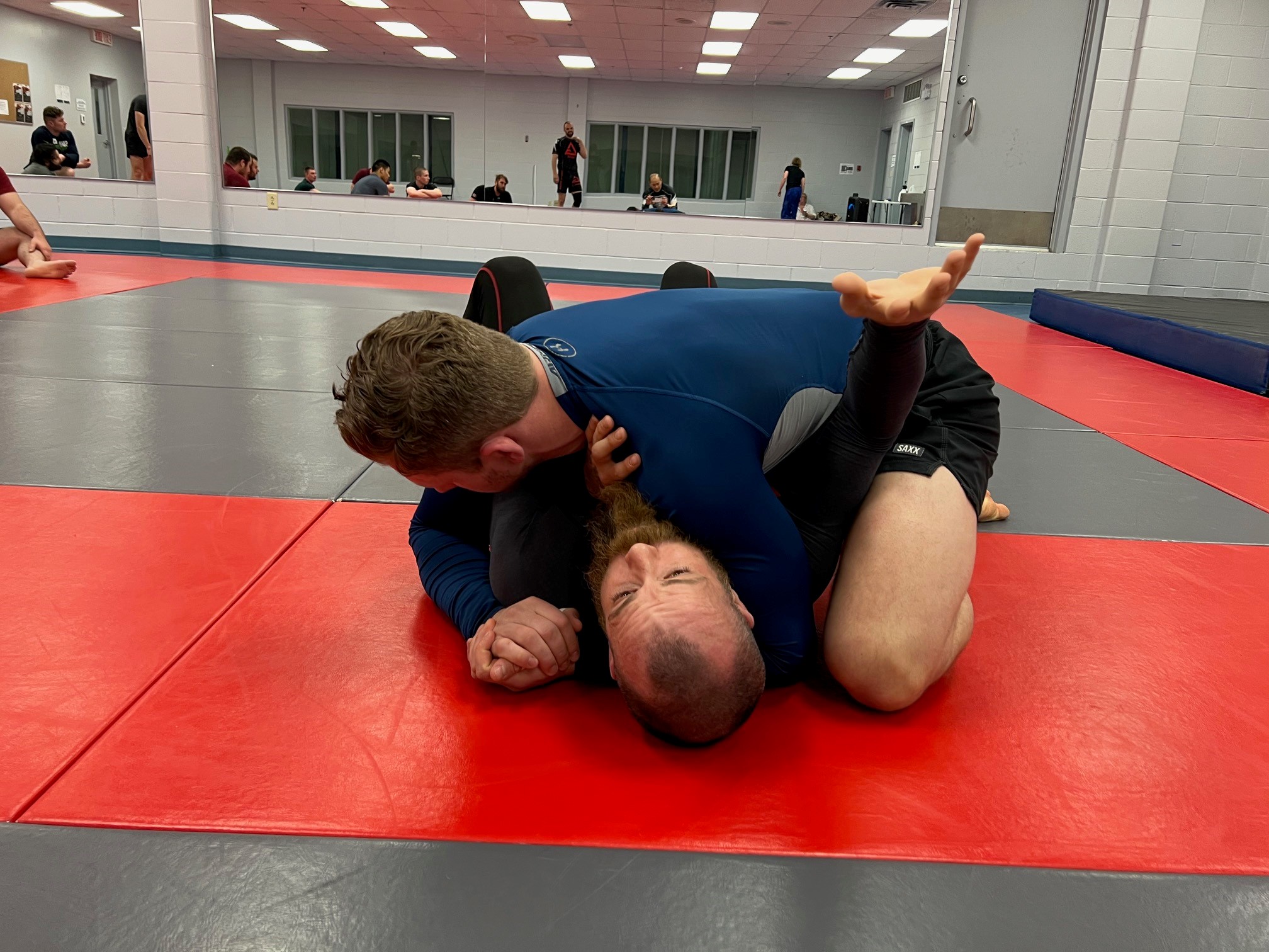 Demonstration - Coach Blake (bottom) and coach Alex (top) demonstrating side control escape to the class
