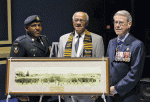 A photo of the No. 2 Construction Battalion on parade grounds in 1916 ipresented to Lt. Gov. Jim Grant, by Dr. Les Oliver, president of the Black Cultural Society. With them is Chief Warrant Officer Steven Milton.