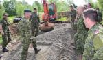 Col Cmdt inspecting drainage work being conducted on the fitness trail on the site of the old ski hill. The Col had done original work on the same ski hill when he was a MCpl. // Le colonel commandant inspecte le travail d’écoulement effectué sur la piste de conditionnement physique sur le site de l’ancienne colline de ski. Le Col avait déjà travaillé sur la même colline alors qu’il était au grade de Cplc.