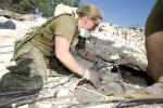 WO Erica Oliver (then Sgt), 5 RGC section commander, looks to see if there are casualties before they take down the damaged building. In Haiti, the Engineers' main purpose was to clean up roads around the country, take down dangerous buildings and build basic structures.// Sgt Erica Oliver, comdt d’une section dans 5 RGC, regarde à l’intérieur d’un bâtiment endommagé pour voir s’il reste des victimes avant de le démolir. L’objectif des ingénieurs canadiens en Haïti consiste à nettoyer les chemins dans l