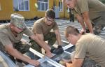 Yavoriv, Ukraine. 15 August 2015 - Members of the Canadian Armed Forces Theatre Activation Team (TAT) and Ukrainian Soldiers assemble the new dining facility at the International Peacekeeping and Security Centre (IPSC) in Yavoriv, Ukraine on August 15, 2015 during Operation UNIFIER. 