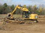 Excavator picking up and moving logs that will be used for future 2 CER operations // Une excavatrice ramasse et déplace des troncs d’arbres qui serviront lors d’opérations futures du 2 RGC