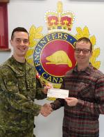 Capt Kevin Elmer from RP Ops Unit West Wainwright presents a bursary cheque to CMEA member WO Raymond Gendron(Ret'd)  on behalf of his son Antoine Gendron who was unable to be present.