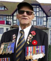 Dan Galipeau in front of Queen's Own Rifles of Canada House in Bernière-sur-Mer