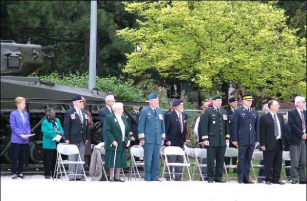 Assembled guests witness unveiling of a plaque commemorating Col Mitchell, VC, MC