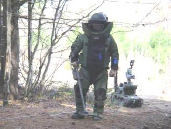An EOD operator using a mine detector to find IEDs