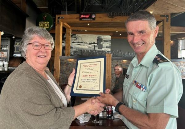 Colonel Commandant presents Pukka Sapper certificate to Izzy Doll Mama Shirley O'Connell