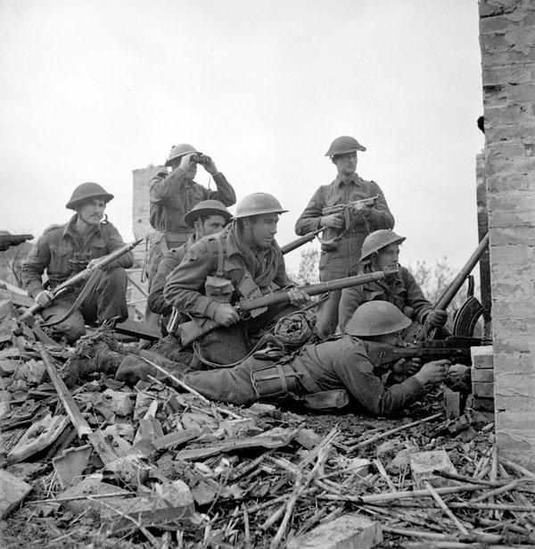 San Leonardo di Ortona, Italy; December 10, 1943: Lt Ian Macdonald of the 48th Highlanders (standing, with binoculars) with (from left) Sgt J.T. Cooney, Pte A.R. Downie, Pte O.E. Bernier, Pte G.R. Young (kneeling, with Lee-Enfield rifle), Cpl T. Fereday and Pte S.L. Hart (lying prone with Bren gun).