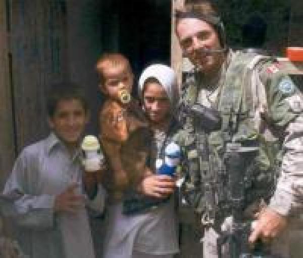 A Canadian soldier‎ in Afghanistan giving Izzy Dolls to children