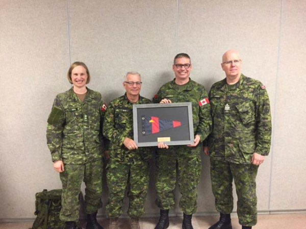 Col Derek Basinger receives the Director RCE framed pennant from Colonel Commandant CME BGen (R) Steve Irwin. From left to right Cmdt CFSME and Deputy Director RCE, LCol Barb Honig, Col Cmdt CME BGen (R) Steve Irwin, Col Basinger and CME CWO, CWO Glenn Simpkin. Photo taken by Maj J. Boddy OC Field Engineer Training Squadron CFSME