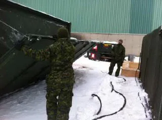Sgt Leclerc supervises the setup of showers and toilets (MECCs used for ablutions)