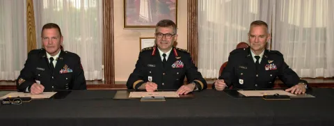 LGen Paul Wynnyk, Commander of the Canadian Army, CWO Alain Guimond, outgoing Army Sergeant Major, (Left) and CWO Stuart Hartnell, incoming Army Sergeant Major (Right) sign the Change of Appointment scroll.