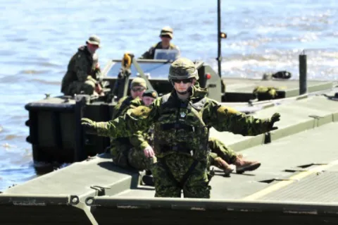 WO Miso Zekanovic directs the placement of the floating bridge to moor it on the shore of the Anse au Foulon // L’adjudant Miso Zekanovic dirige le pont flottant afin de pouvoir l’accoster sur la rive de l’Anse au Foulon. Photo : Lt Isabelle Provost
