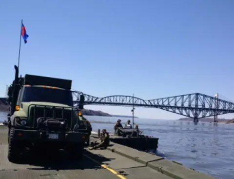 35 CER members transport an MSVS vehicle on a floating bridge set up on the St. Lawrence River // Les membres du 35e RGC transportent un véhicule MSVS sur un pont flottant monté sur le Fleuve St-Laurent. Photo : Lt Isabelle Provost