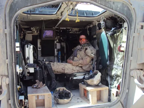 Brigadier-General Jennie Carignan, the commanding officer of Task Force Kandahar Engineer Regiment, takes a break in her Light Armoured Vehicle III in the District of Arghandab, Afghanistan in June 2010./Le Bgén Jennie Carignan, alors commandant du régiment de génie de la Force opérationnelle Kandahar, prend une pause dans son véhicule blindé léger III dans le district d’Arghandab, en Afghanistan, en juin 2010. 