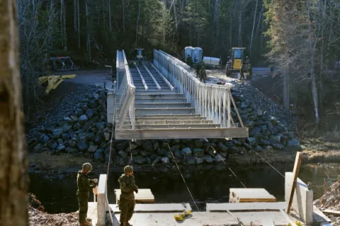 Combat engineers work on the bridge across the Tetagouche River that will be used by recreational vehicles year round. (5th Canadian Division/Contributed)/Des sapeurs de combat construisent le pont de la rivière Tetagouche, lequel sera ouvert à l’année aux véhicules récréatifs. (Photo : contribution de la 5e Division du Canada)