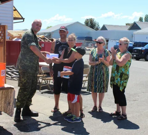 Maj Fenton handing Comox chapter contributions to Marc, Kaitha and their family