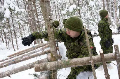 Cpl David Houde builds a lean-to during the winter warfare course conducted at Lake Hayes //  Le cpl David Houde construit un appentis lors du cours de guerre hivernale qui s’est déroulé au Lac Hayes.  Le cpl David Houde construit un appentis lors du cours de guerre hivernale qui s’est déroulé au Lac Hayes.     (Photo: Lt Isabelle Provost)