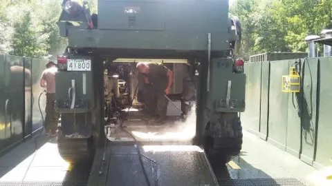 Mechanics are cleaning an M113 before going for maintenance // Mécaniciens en train de laver un M113 avant d’être envoyé pour maintenance