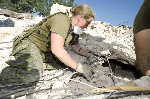WO Erica Oliver (then Sgt), 5 RGC section commander, looks to see if there are casualties before they take down the damaged building. In Haiti, the Engineers' main purpose was to clean up roads around the country, take down dangerous buildings and build basic structures.// Sgt Erica Oliver, comdt d’une section dans 5 RGC, regarde à l’intérieur d’un bâtiment endommagé pour voir s’il reste des victimes avant de le démolir. L’objectif des ingénieurs canadiens en Haïti consiste à nettoyer les chemins dans l