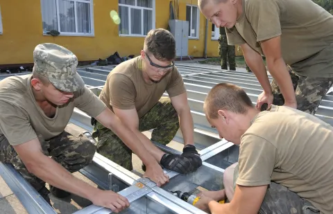 Yavoriv, Ukraine. 15 August 2015 - Members of the Canadian Armed Forces Theatre Activation Team (TAT) and Ukrainian Soldiers assemble the new dining facility at the International Peacekeeping and Security Centre (IPSC) in Yavoriv, Ukraine on August 15, 2015 during Operation UNIFIER. 