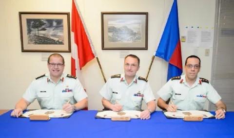 BGen A.R. Jayne, CD (Outgoing Branch Advisor), MGen J.S. Sirois, OMM, CD (CAF Chief Military Engineer), Col M. Gros-Jean, CD (Incoming Branch Advisor) signing the Branch Advisor change of appointment certificate