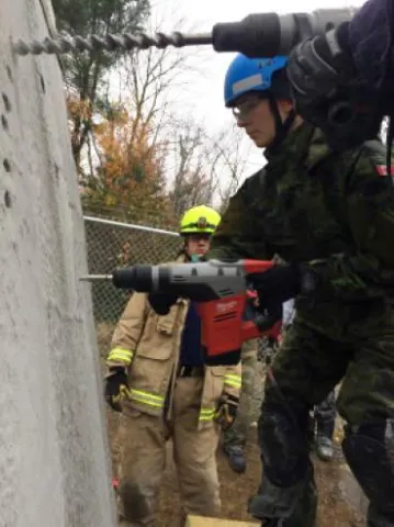 Avr Alana Litz (19 Wing) drills holes in order to safely remove a large chunk of concrete. (Photo by Capt M Sukstorf)